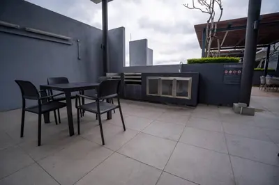 a table and chairs sitting on a patio at Neu Suites By Cozy Unit L20RB near KLCC & Jelatek LRT in Kuala Lumpur