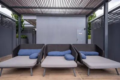 two wicker benches with blue pillows on a patio at Neu Suites By Cozy Unit L20RB near KLCC & Jelatek LRT in Kuala Lumpur