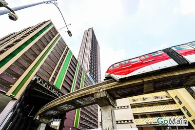 a train on a bridge in a city with buildings at 24h Check in & SkyPool- KL Sentral Suite Riveria City Near KL Sentral KL KLCC in Kuala Lumpur