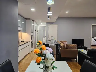 a kitchen and living room with a table with flowers on it at St Mary Pavilion KLCC 3BR6Pax in Kuala Lumpur
