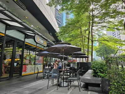 a group of people sitting at a table under an umbrella at St Mary Pavilion KLCC 3BR6Pax in Kuala Lumpur