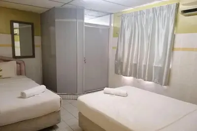 a room with two beds and a window in it at Hotel Dlima House Bukit Bintang in Kuala Lumpur