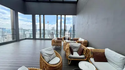 a balcony with wicker chairs and tables on a building at Cozy Axon Residence Bukit Bintang by Konoha Suites 1-6pax in Kuala Lumpur