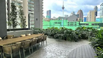 a restaurant with tables and chairs on a rooftop at Cozy Axon Residence Bukit Bintang by Konoha Suites 1-6pax in Kuala Lumpur