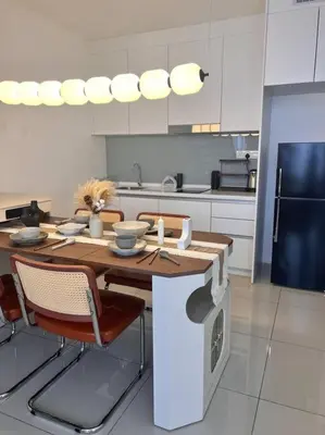 a kitchen with a wooden table and chairs in a kitchen at Tranquil Den EkoCheras KL in Kuala Lumpur