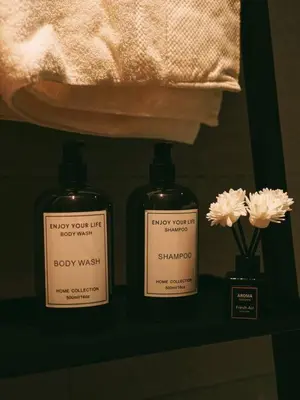 two bottles of baby wash on a shelf with flowers at Tranquil Den EkoCheras KL in Kuala Lumpur