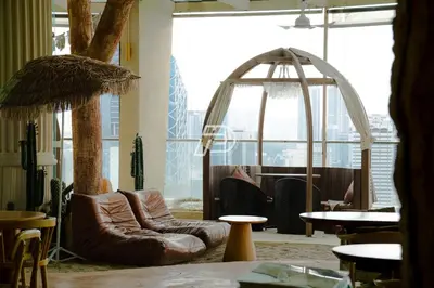 a room with leather chairs and tables and a large window at Infinity Pool Dorms KLCC View by Regalia in Kuala Lumpur