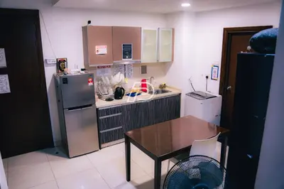 a small kitchen with a table and a refrigerator at Infinity Pool Dorms KLCC View by Regalia in Kuala Lumpur
