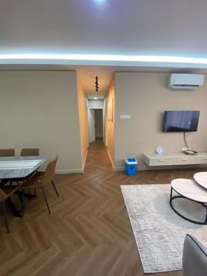 a living room with a table and a flat screen tv at Best Spot in City in Kuala Lumpur