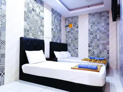 a bedroom with two beds with white and blue walls at ARK Ampang Tesco Hotel in Kuala Lumpur
