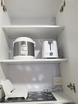a coffee maker and a toaster sitting on shelves at Arte Mont Kiara Studio,Kuala Lumpur in Kuala Lumpur