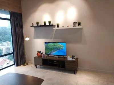 a living room with a flat screen tv on a cabinet at 2-Bedroom Apartment in Kuala Lumpur City Center in Kuala Lumpur