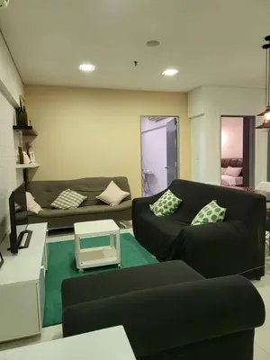 a living room with a black couch and a table at Prime Summer Suites KLCC in Kuala Lumpur
