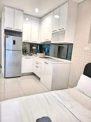 a kitchen with white cabinets and a refrigerator at Prime Summer Suites KLCC in Kuala Lumpur