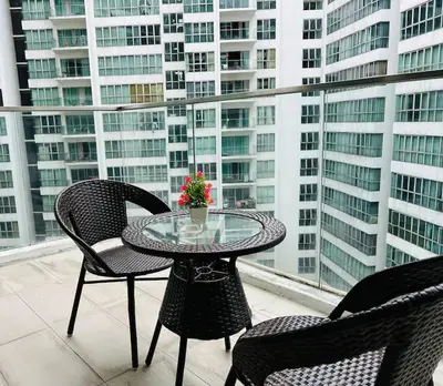a table and chairs on a balcony with a view of buildings at Regalia Residence By Willow Home in Kuala Lumpur