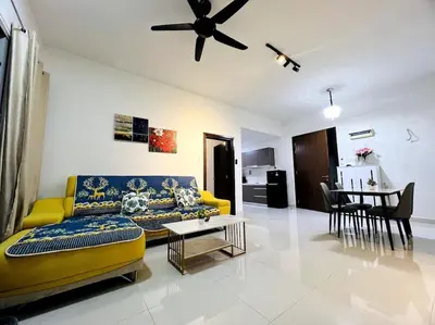a living room with a yellow couch and a table at Regalia Residence By Willow Home in Kuala Lumpur