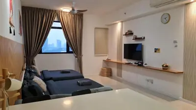 a living room with a couch and a tv at Chambers Suites KLCC By Glory Homes in Kuala Lumpur