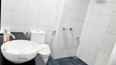a white bathroom with a sink and a toilet at Chambers Suites KLCC By Glory Homes in Kuala Lumpur