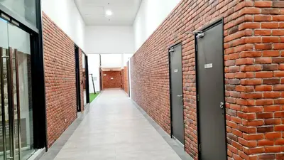a corridor of a red brick wall with a door at Chambers Suites KLCC By Glory Homes in Kuala Lumpur