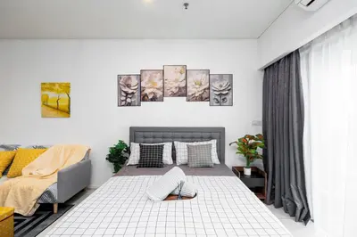 a white bedroom with a bed and a couch at Twin Towers Suites - 7mins walking to KLCC in Kuala Lumpur