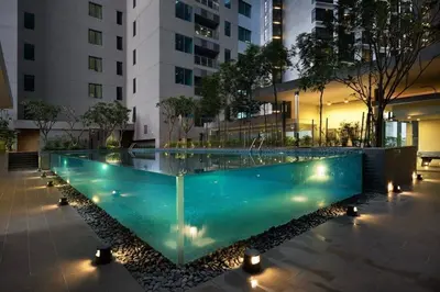 a swimming pool in the middle of a building with lights at Twin Towers Suites - 7mins walking to KLCC in Kuala Lumpur