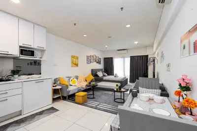 an open kitchen and living room with white cabinets at Twin Towers Suites - 7mins walking to KLCC in Kuala Lumpur