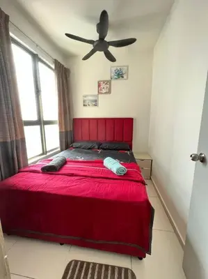 a bedroom with a red bed with a ceiling fan at Cozy kenwingston platz kl 2-5pax 2BR&2BR Klcc view pakin netflx 3705A in Kuala Lumpur