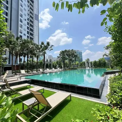 a large swimming pool with chairs and grass at Maxhome-Agile Bukit Bintang TRX in Kuala Lumpur