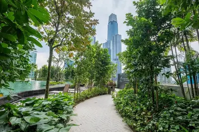 a walkway in a park with a city skyline at Maxhome-Agile Bukit Bintang TRX in Kuala Lumpur