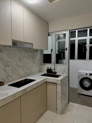 a white kitchen with a sink and a washing machine at Naaa homee in Kuala Lumpur