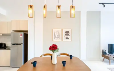 a kitchen with a table with a vase of flowers at Inspirasi at Mont Kiara by Airhost in Kuala Lumpur