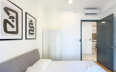 a bedroom with a white bed and a mirror at Inspirasi at Mont Kiara by Airhost in Kuala Lumpur
