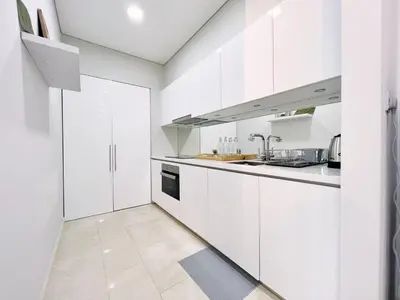 a white kitchen with white cabinets and a sink at Sky Suites Airy 2BR Suite at KLCC in Kuala Lumpur