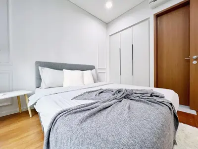 a bedroom with a bed with a gray blanket at Sky Suites Airy 2BR Suite at KLCC in Kuala Lumpur