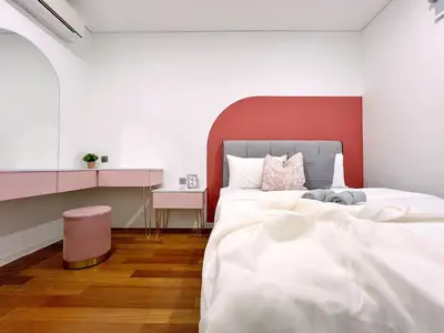a bedroom with a white bed with a red headboard at Sky Suites Blush 3BR Suite at KLCC in Kuala Lumpur