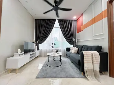 a living room with a black couch and a tv at Sky Suites Central 2BR Suite KLCC View in Kuala Lumpur