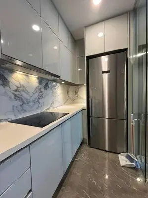 a kitchen with white cabinets and a stainless steel refrigerator at Facestyle Infinity Pool KLCC Smart TV Free WiFi Two Bedroom in Kuala Lumpur