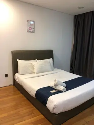a bed with a pair of shoes on top of it at KL Suites Apartment at Vortex in Kuala Lumpur