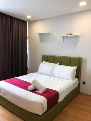 a bed with a red and white blanket on it at KL Suites Apartment at Vortex in Kuala Lumpur