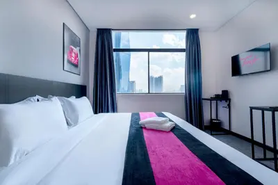 a bedroom with a large white bed with a window at TEEDO Hotel Kuala Lumpur in Kuala Lumpur