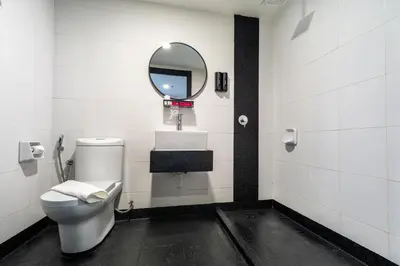a bathroom with a toilet and a mirror at TEEDO Hotel Kuala Lumpur in Kuala Lumpur