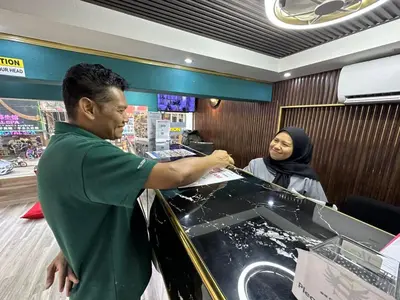 a man and a woman standing behind a counter at SS Grey Hotel Bukit Bintang in Kuala Lumpur