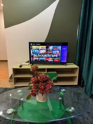 a room with a glass table with a vase of flowers and a tv at #breathtaking#zetaparkmall#klcc#Honeymoon#2p#118 in Kuala Lumpur