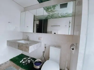 a bathroom with a sink and a toilet and a mirror at Deluxe Family Suites w KLCC View in Kuala Lumpur