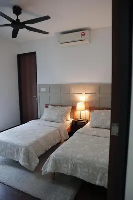 a bedroom with two beds and a ceiling fan at The Bohomes with KLCC view in Kuala Lumpur