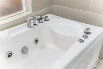 a white bath tub with a white sink at Relaxing Muji Retreat with Jacuzzi, Retro Games, MRT in Kuala Lumpur