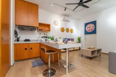 a kitchen with wooden cabinets and a table in a room at Relaxing Muji Retreat with Jacuzzi, Retro Games, MRT in Kuala Lumpur