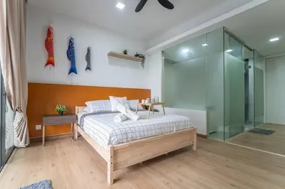 a bedroom with a bed and a glass wall at Relaxing Muji Retreat with Jacuzzi, Retro Games, MRT in Kuala Lumpur