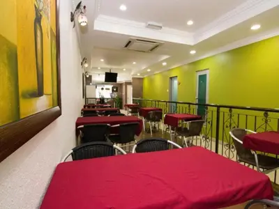 a restaurant with red tables and chairs on a balcony at OYO 103 V'la Garden Hotel in Kuala Lumpur
