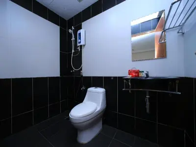 a bathroom with a white toilet and a mirror at OYO 115 Hotel Safari 1 in Kuala Lumpur